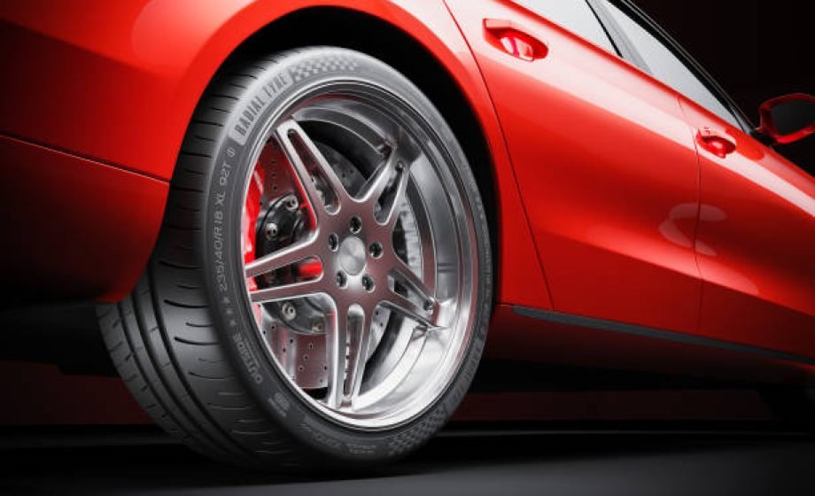 Wheel of red sports car closeup in studio lighting 3d render